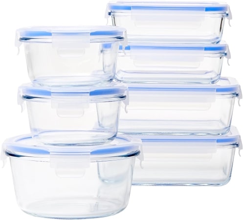 Six clear glass food storage containers with matching lids arranged neatly on a countertop, showcasing their transparent design.