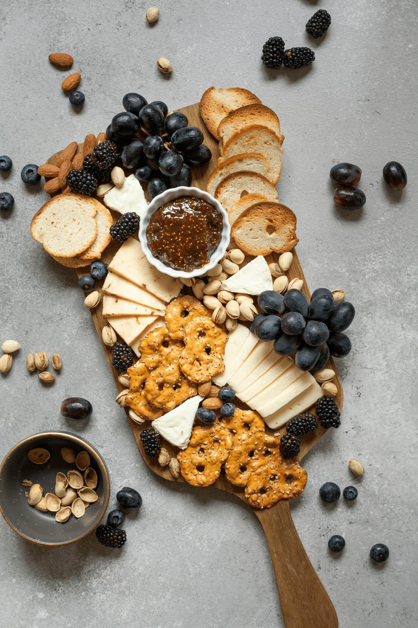 A wooden board featuring an assortment of cheese, nuts, and fresh berries arranged artfully for a delightful presentation.