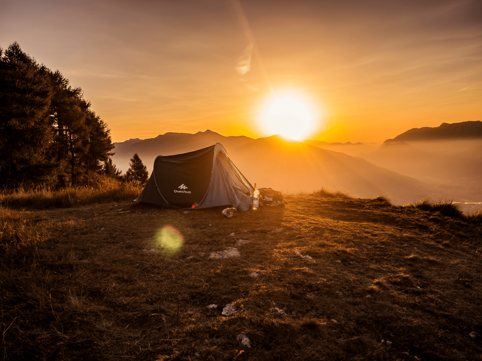 Scenic sunset view with a tent and some supplies in the foreground