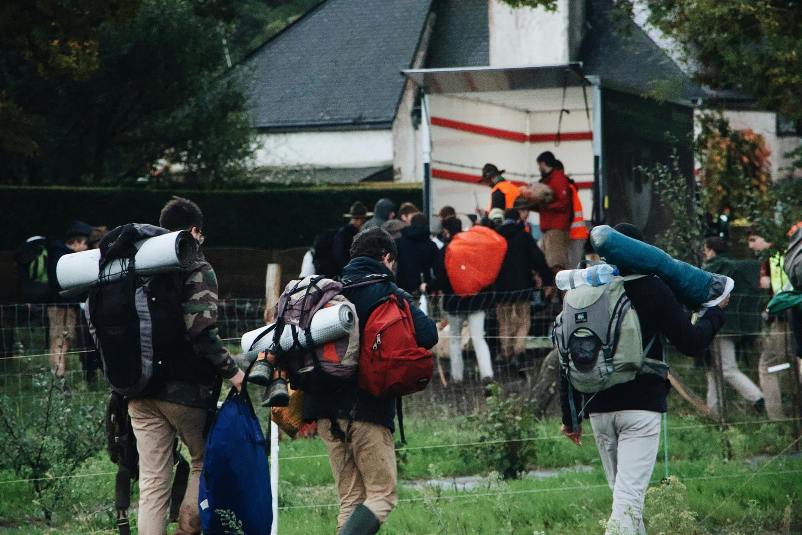 A diverse group of individuals walking together, each carrying a backpack, enjoying an outdoor adventure.