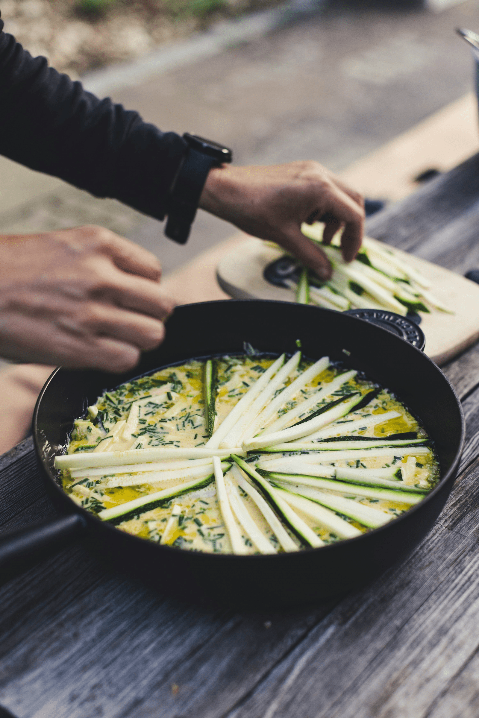 A person skillfully cooks a dish in a pan, showcasing culinary techniques and vibrant ingredients.