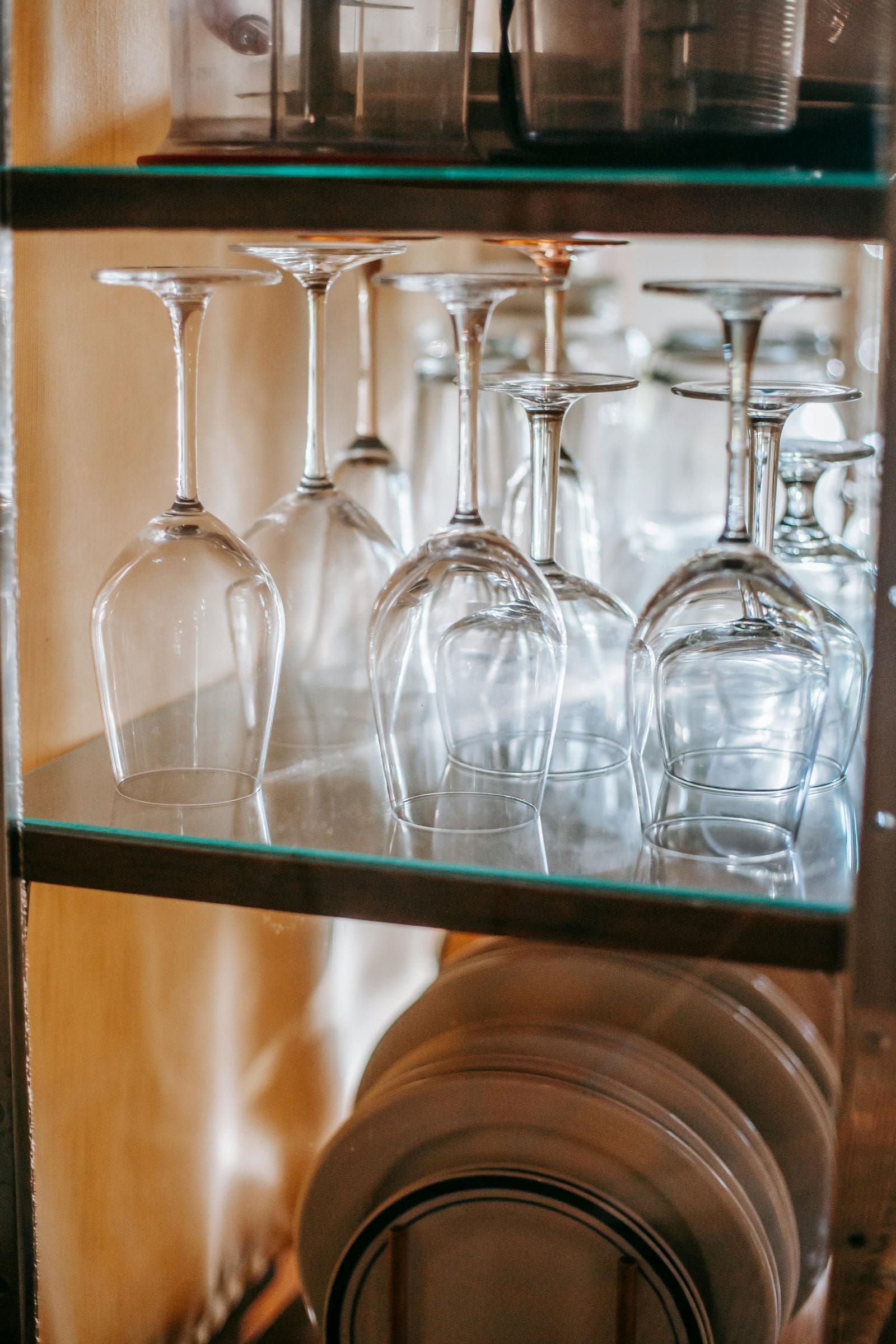 A shelf displaying an assortment of wine glasses and plates, elegantly arranged for a refined dining experience.