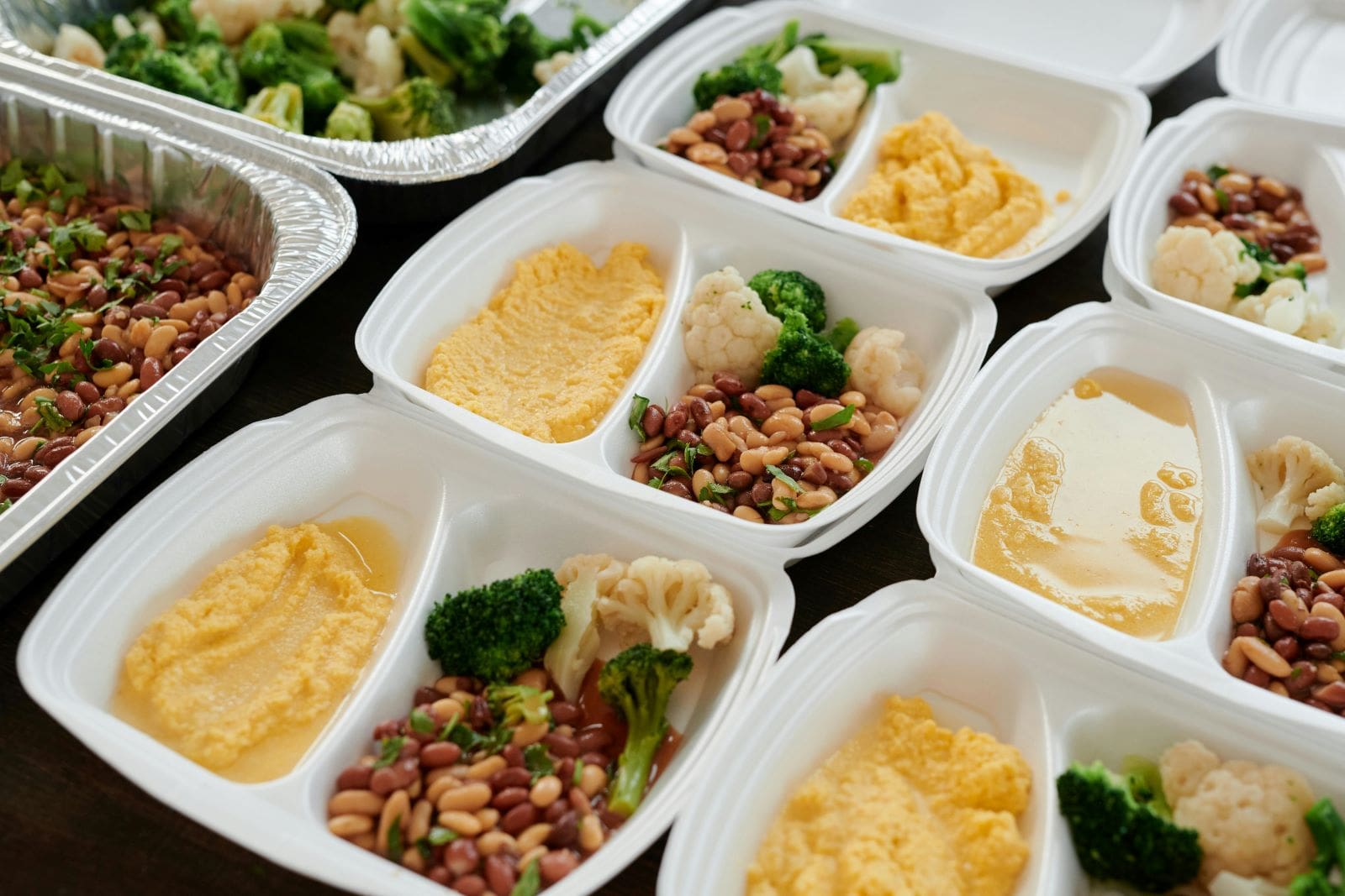 A table displaying various containers filled with an assortment of food items, ready for serving or sharing.