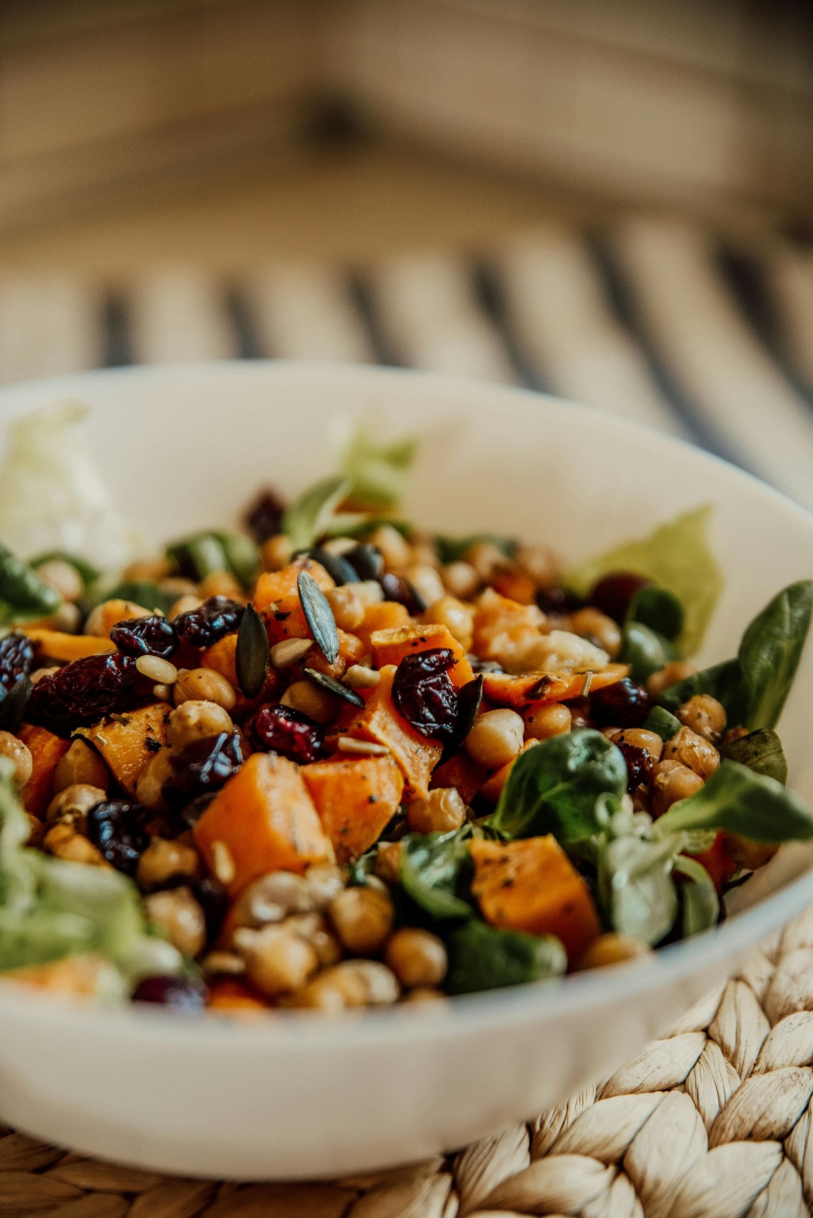 A vibrant bowl of salad featuring fresh spinach, assorted nuts, and colorful beans, showcasing a healthy meal option.