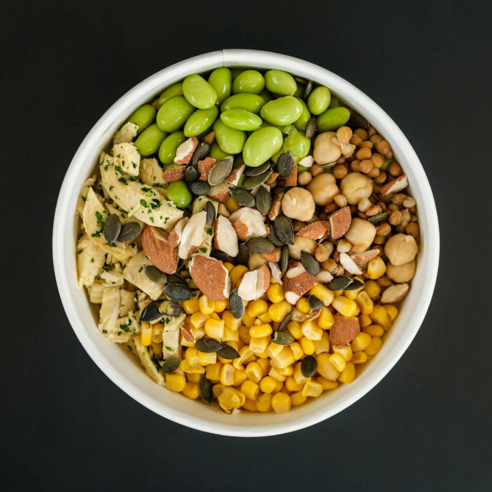 A bowl filled with a variety of nuts and seeds, showcasing an assortment of textures and colors.