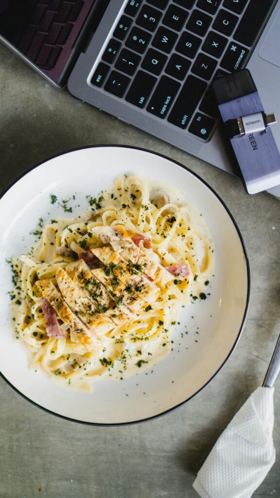 A plate of pasta topped with savory meat and melted cheese, garnished for an appetizing presentation.