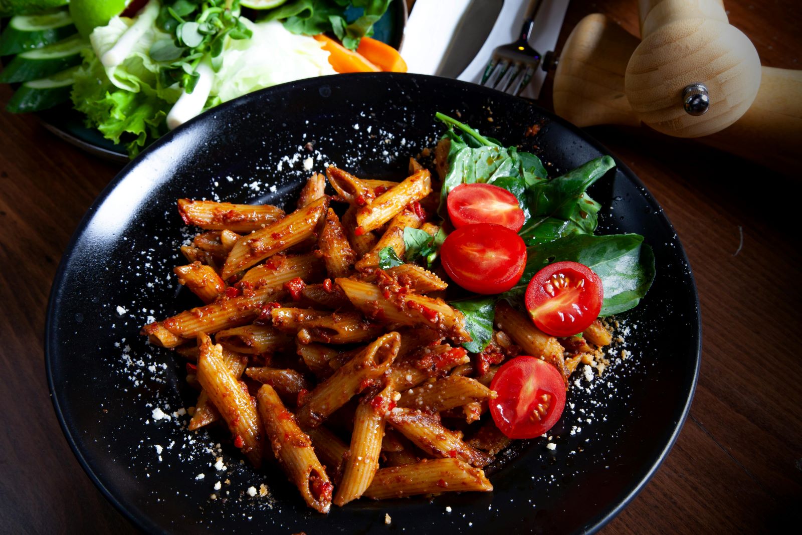 A plate of pasta topped with fresh tomatoes and melted cheese, showcasing a vibrant and appetizing dish.